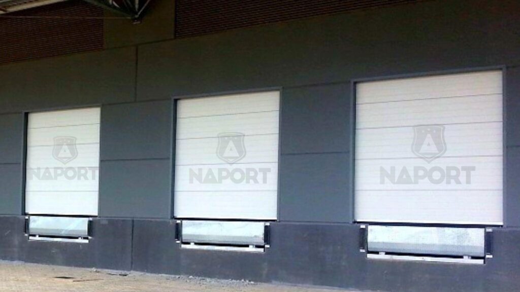 As portas de enrolar ou seccionais são excelentes barreiras de proteção para galpões e hangares